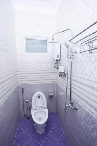 a small bathroom with a toilet and a shower at Huis Van Gustafine Floor 1 in Malang
