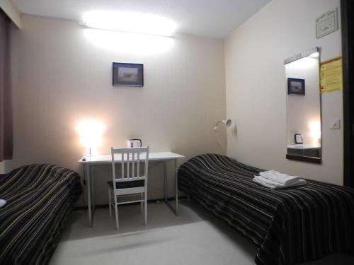 a room with a desk and a bed and a chair at Hotelli Anna Kern in Imatra
