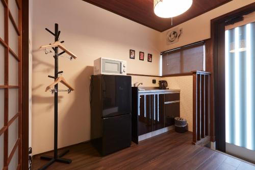 a kitchen with a black refrigerator and a microwave at Ikoi Demachiyanagi in Kyoto