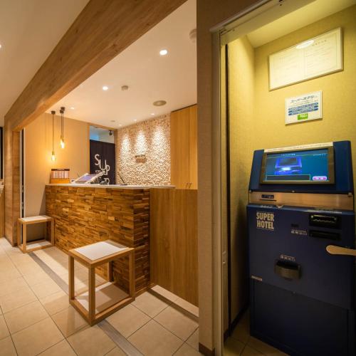 a lobby with a video poker machine and a bar at Super Hotel Okinawa Nago in Nago