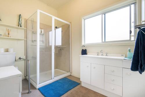 a bathroom with a shower and a sink at Nautique Beach House - Rustic and Charming, Walk 2 Beach & Shops in Rosebud