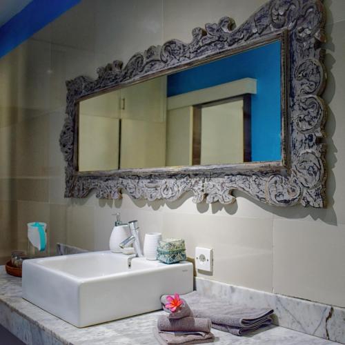 a bathroom with a sink and a mirror on the wall at Pandana Boutique Hotel in Nusa Lembongan