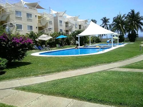 a swimming pool in front of a large building at Pent House Acapulco Diamante Markis K 31 in Acapulco