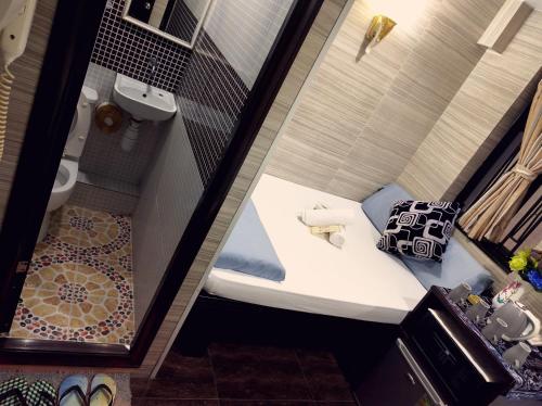 mały pokój z łóżkiem i toaletą w obiekcie Melbourne Hostel Block E 10th floor w Hongkongu