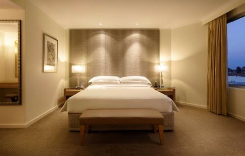 - une chambre avec un grand lit et une fenêtre dans l'établissement Hyatt Regency Perth, à Perth