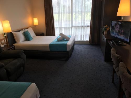 a hotel room with two beds and a television at Australia Park Motel in Albury