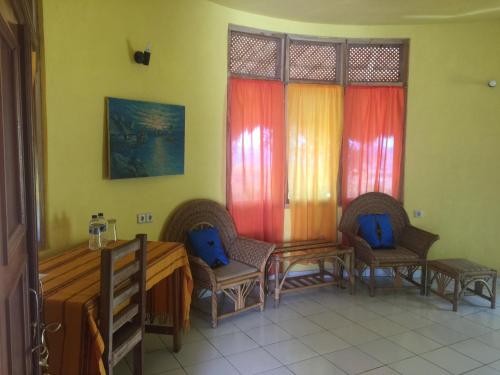 um quarto com duas cadeiras, uma mesa e janelas em Oro Beach Houses em Weetebula