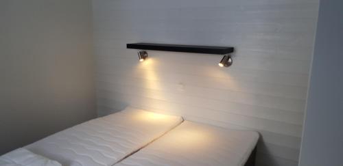 Habitación pequeña con cama con luces en la pared en Rättviks Golfby, en Rättvik