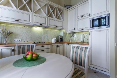 a kitchen with a bowl of fruit on a table at Life Inn Apartments in Saint Petersburg