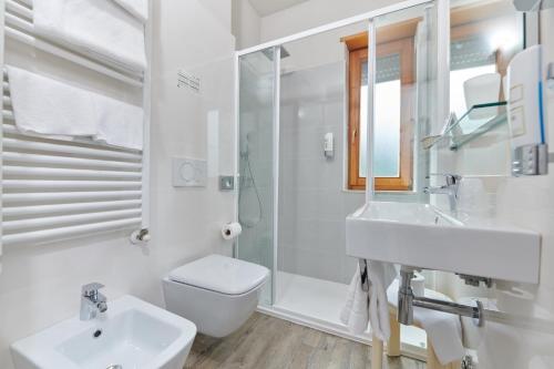 a white bathroom with a sink and a toilet at Eco Hotel Benacus in Malcesine
