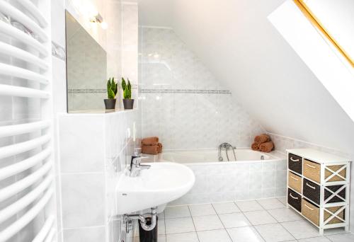 a white bathroom with a sink and a bath tub at Lifestyle-Appartement Meersinn in Waren