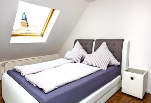 a bed with white and purple sheets and pillows at Lifestyle-Appartement Meersinn in Waren