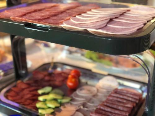 a tray of meats and other foods on a buffet at Landhotel Traube in Baden-Baden