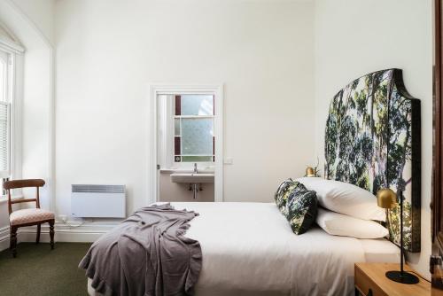 a bedroom with a bed and a chair and a window at The Florance in Launceston