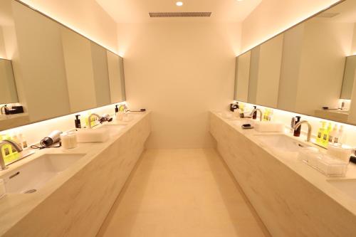a bathroom with three sinks and two mirrors at LEO YU Capsule Hotel Nishifunabashi in Funabashi