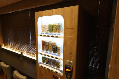 a refrigerator with cans of beer in a room at LEO YU Capsule Hotel Nishifunabashi in Funabashi