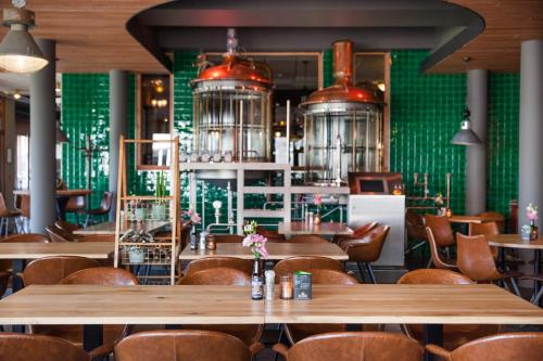 un restaurante con mesas y sillas de madera y paredes verdes en Hotel Parkzicht, en Veendam