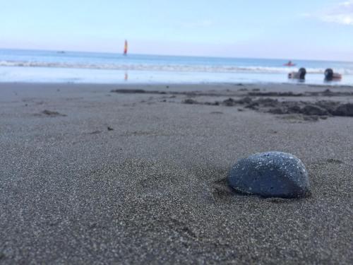 a rock in the sand on a beach at Tamowan in Donghe