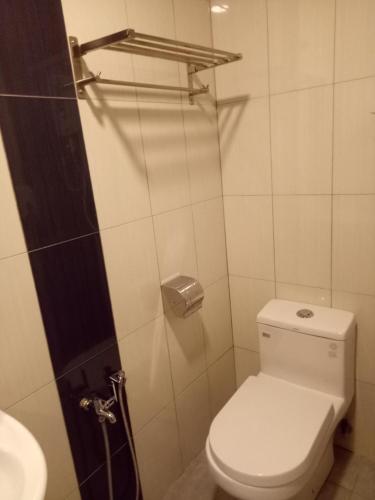 a white bathroom with a toilet and a sink at Hotel Sri Bernam in Sabak Bernam