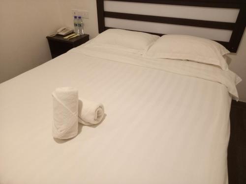 a white bed with two towels sitting on it at Hotel Sri Bernam in Sabak Bernam