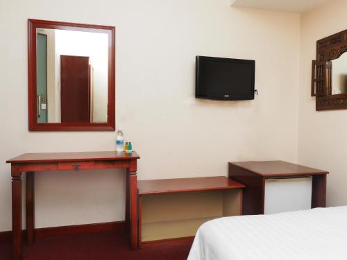 a hotel room with a bed and a mirror and a television at Sun Inns Hotel Subang in Subang Jaya