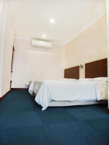 a bedroom with two beds and a blue carpet at Sun Inns Hotel Subang in Subang Jaya