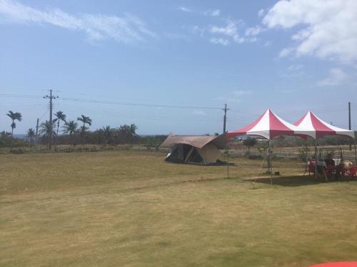 a group of tents in a field with people sitting under them at Tamowan in Donghe