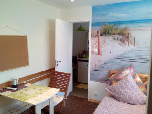 Cette chambre dispose d'une table et d'une porte menant à une plage. dans l'établissement ElitasBB, à Carnikava