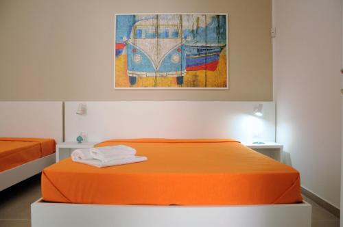 een oranje bed in een kamer met een schilderij aan de muur bij Punta Prosciutto GMA Tourism in Porto Cesareo