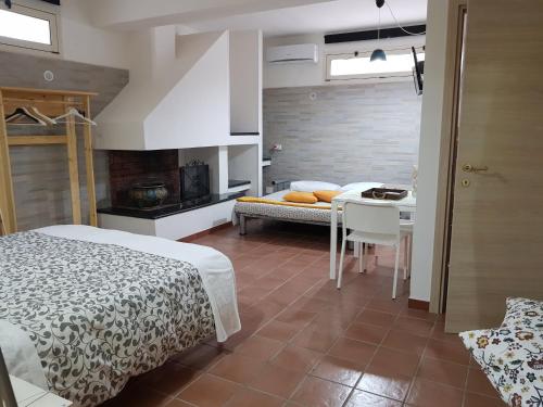 a bedroom with two beds and a table and a kitchen at La Macchia in Melendugno