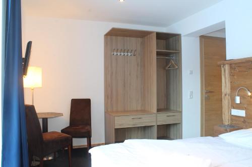 a bedroom with a bed and a cabinet and a desk at Ferienhaus Fassl in Saalbach Hinterglemm