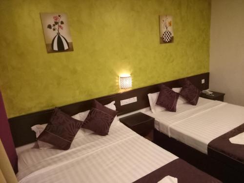 En eller flere senge i et værelse på Hotel Sri Bernam
