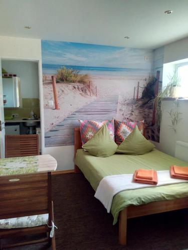a bedroom with two beds and a painting of a beach at ElitasBB in Carnikava