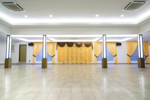 a ballroom with yellow curtains and a dance floor at Hotel Sri Bernam in Sabak Bernam