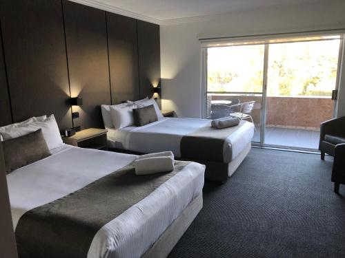 a hotel room with two beds and a window at Huskisson Beach Motel in Huskisson