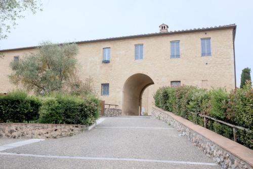 a large brick building with an archway in front at la Senesina in Monteriggioni