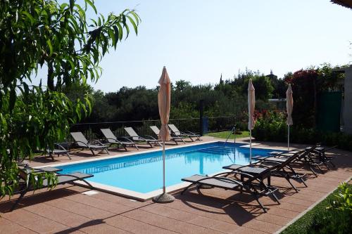 a swimming pool with lounge chairs and umbrellas at Apartments Tabain in Mlini