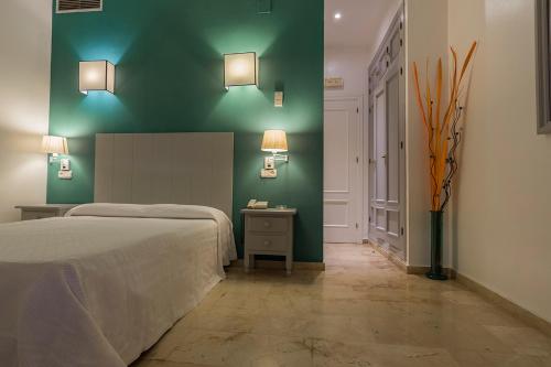 a bedroom with a bed and a green wall at Hostal Drago in Pueblo Nuevo de Guadiaro