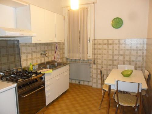 una cucina con tavolo, lavandino e piano cottura di La zucca violina a Ferrara