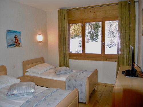1 dormitorio con 2 camas y ventana en Résidence RoyAlp - Appartement 22A, en Villars-sur-Ollon