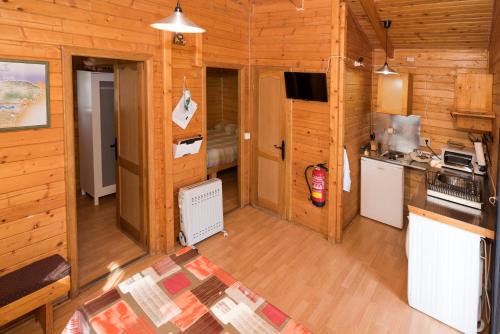 eine Küche und ein Wohnzimmer in einem Blockhaus in der Unterkunft Cabañas Vallecino in Manzanal de los Infantes