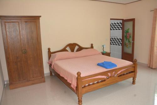 a bedroom with a bed and a wooden cabinet at Apple Bungalows in Bang Saphan