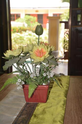 a flower arrangement in a red pot on a table at Apple Bungalows in Bang Saphan