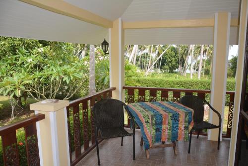 a porch with a table and chairs on it at Apple Bungalows in Bang Saphan