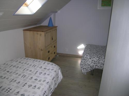 a bedroom with a bed and a dresser and a window at Ti Gwen in Plonévez-du-Faou