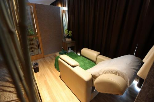a hospital room with a bed and a green blanket at Odua Weston Jambi in Jambi