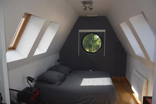 1 dormitorio con 1 cama y ventana redonda en Amiens LOFT, en Amiens