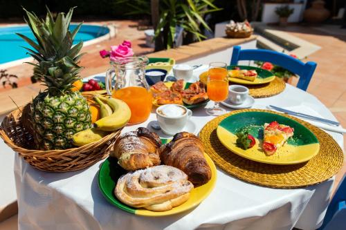 een tafel met borden ontbijtproducten en fruit bij Relais Le Nereidi in San Vito lo Capo