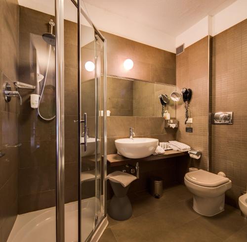 łazienka z umywalką, toaletą i prysznicem w obiekcie Best Western Plus Hotel Farnese w mieście Parma