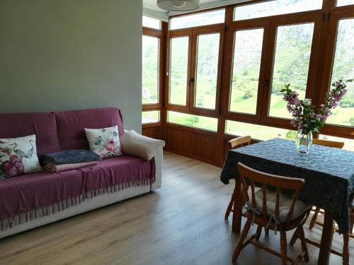 sala de estar con sofá púrpura y mesa en Pico San Carlos ll en Bejes